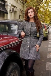 a lady in a grey tweed dress with a belt